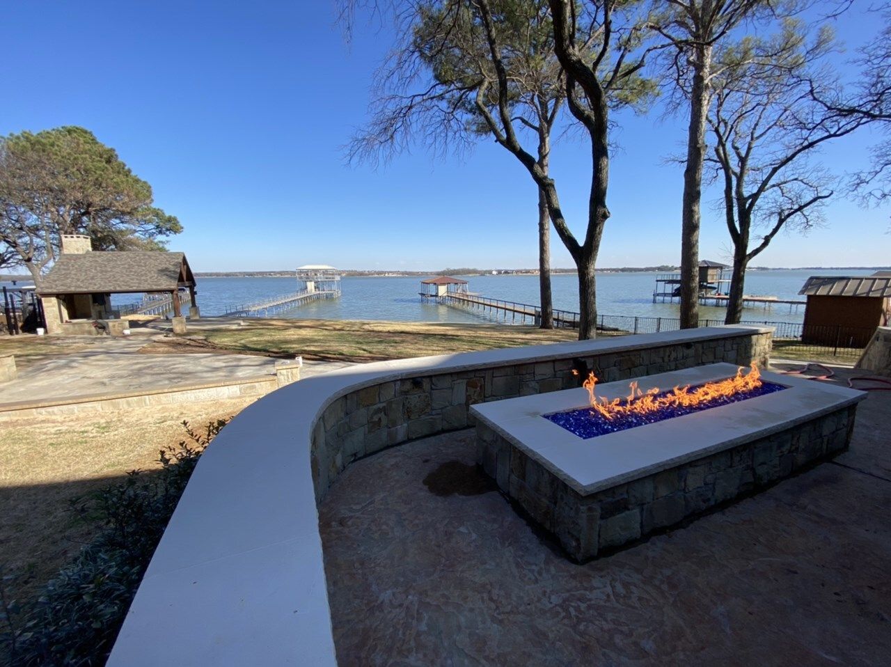 Linear fire feature and seat wall being finished on the lakeside patio