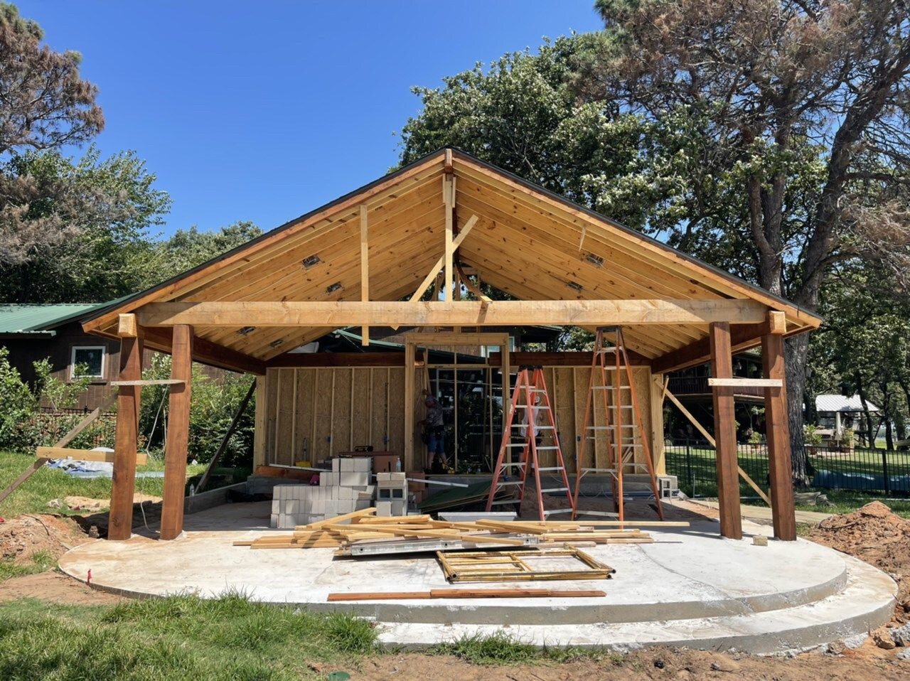 Timber pavilion frame and posts going up on a new curved slab
