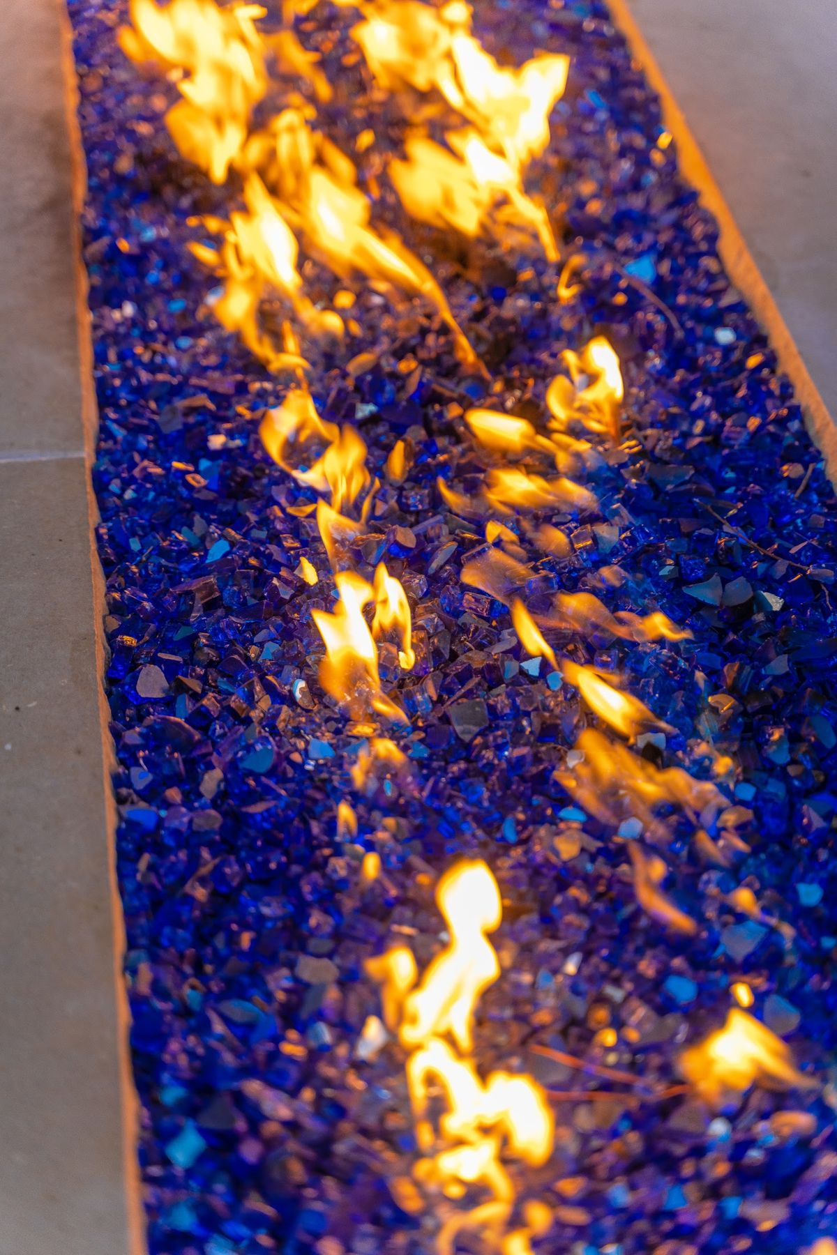 Linear fire feature with blue fire glass