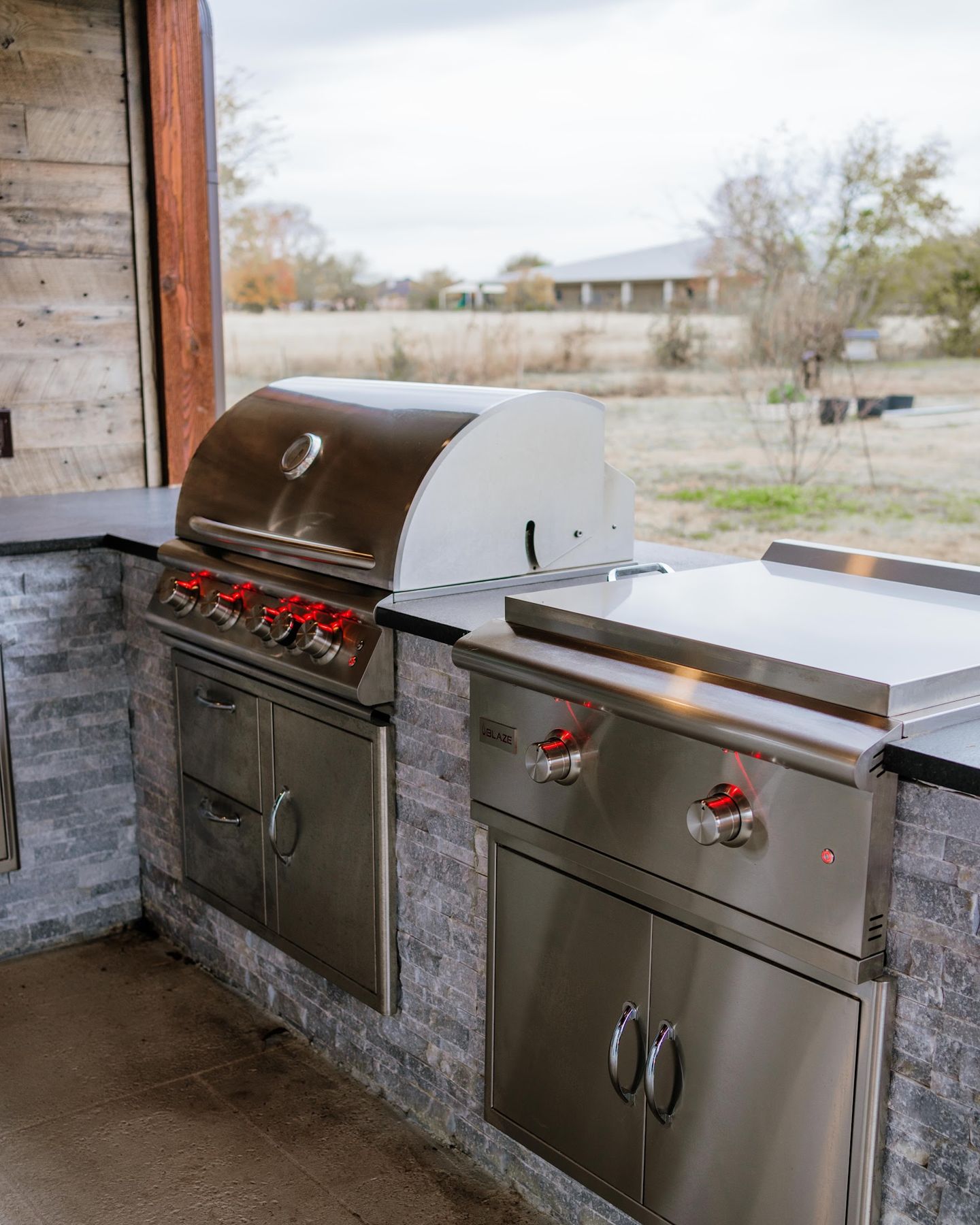Built-in stainless gas grill and griddle in a stone island